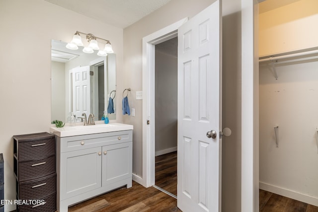 bathroom with vanity, wood-type flooring, and a textured ceiling