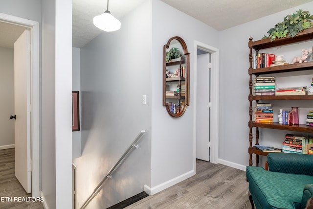 hallway featuring a textured ceiling and light wood-type flooring