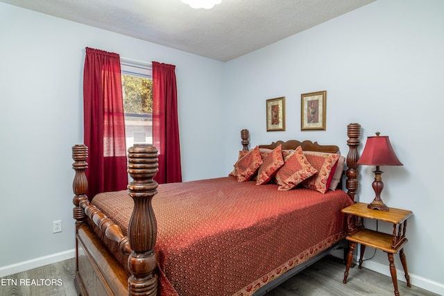 bedroom featuring hardwood / wood-style floors and a textured ceiling