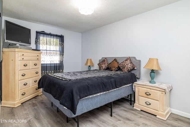 bedroom with hardwood / wood-style flooring and a textured ceiling