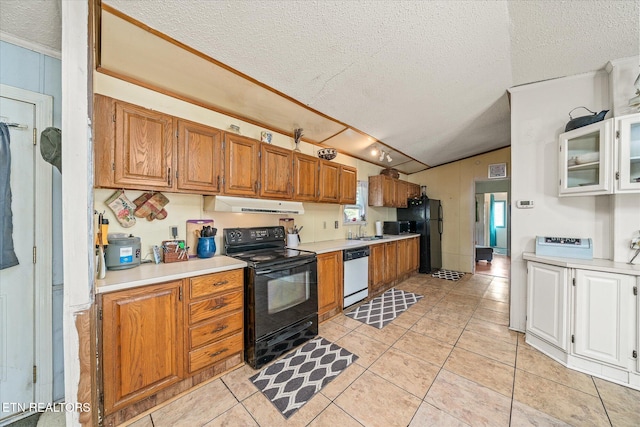 kitchen with sink, light tile patterned floors, black appliances, and a textured ceiling