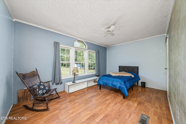 bedroom with crown molding, a textured ceiling, and light hardwood / wood-style flooring