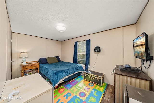 bedroom with a textured ceiling and wood-type flooring