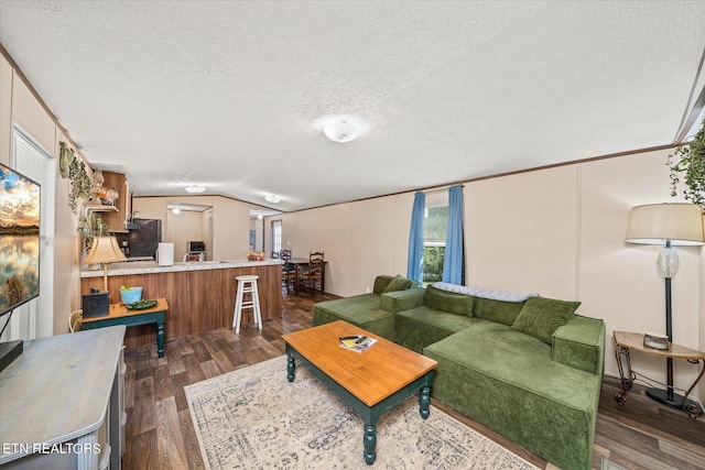 living room featuring a textured ceiling, lofted ceiling, and dark hardwood / wood-style floors