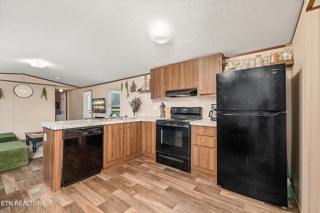 kitchen with black appliances, a textured ceiling, light hardwood / wood-style floors, vaulted ceiling, and range hood