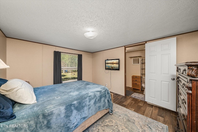 bedroom featuring a textured ceiling and dark hardwood / wood-style flooring