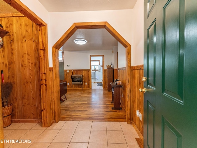 entrance foyer featuring wooden walls, light hardwood / wood-style floors, and heating unit