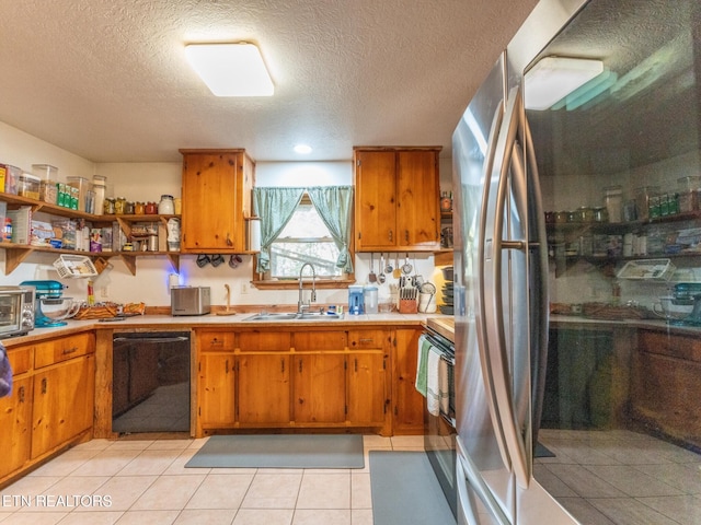 kitchen featuring light tile patterned flooring, sink, a textured ceiling, stainless steel refrigerator, and black dishwasher