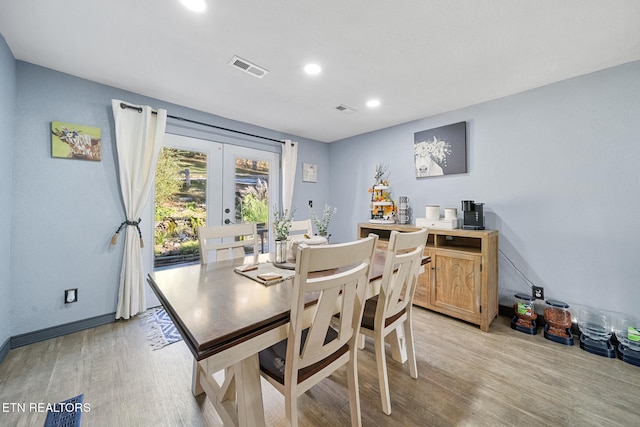 dining space with french doors and light hardwood / wood-style floors