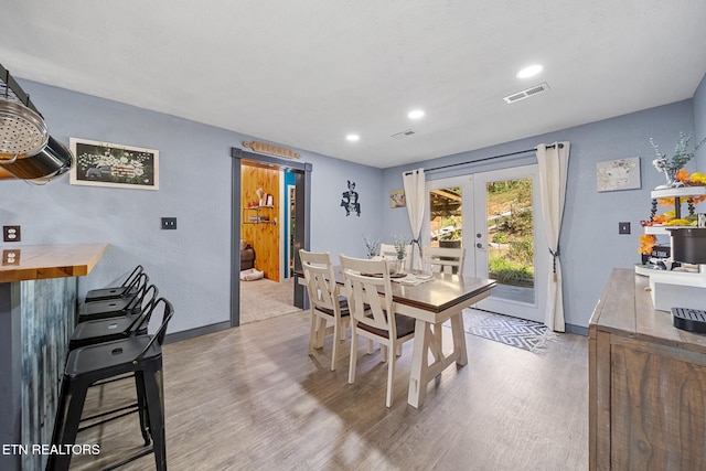 dining room featuring french doors and light hardwood / wood-style flooring