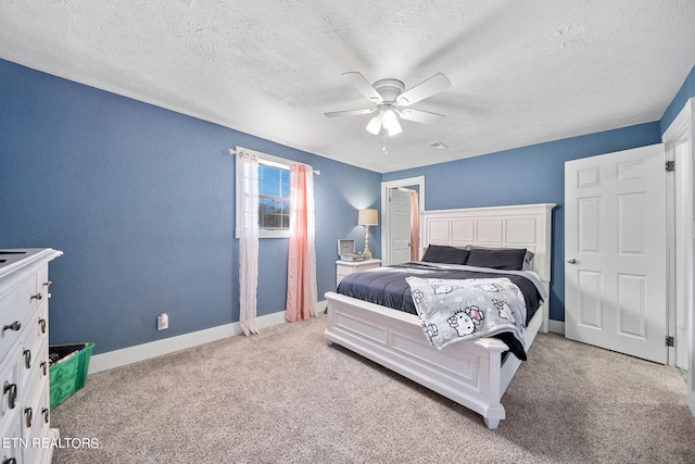 bedroom featuring light carpet, a textured ceiling, and ceiling fan