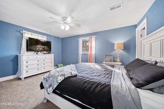 carpeted bedroom with ceiling fan and a textured ceiling