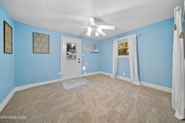 carpeted spare room with ceiling fan