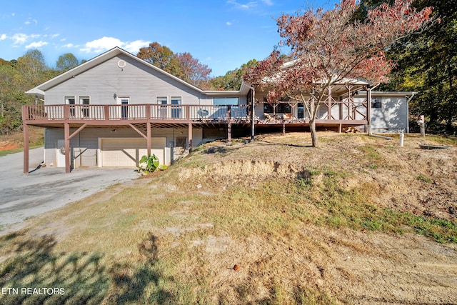 back of property with a deck and a garage