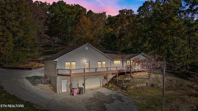 view of front facade with central air condition unit, a deck, and a garage