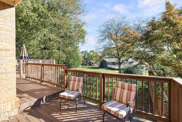 wooden terrace featuring a lawn