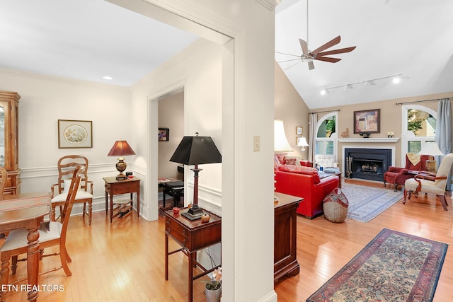 living room featuring ceiling fan, ornamental molding, and light wood-type flooring