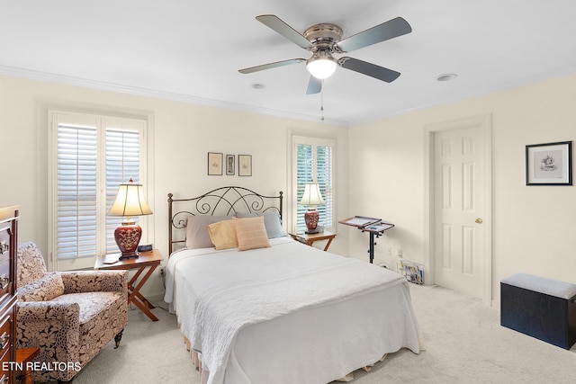 carpeted bedroom featuring ceiling fan, ornamental molding, and multiple windows