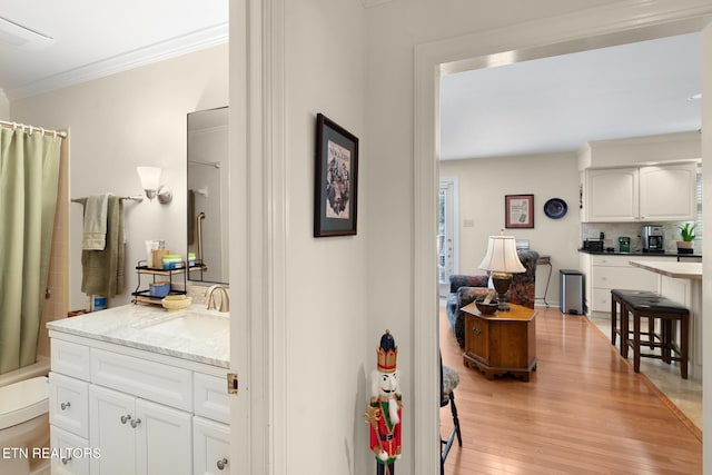 interior space featuring ornamental molding, sink, and light hardwood / wood-style floors