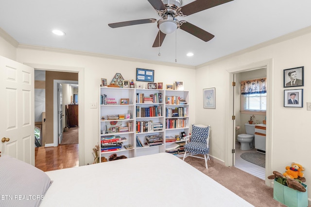 bedroom featuring ceiling fan, carpet flooring, ensuite bathroom, and ornamental molding