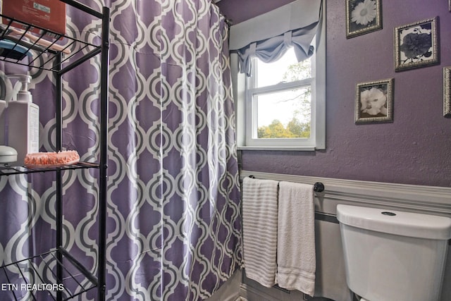 bathroom featuring toilet and walk in shower