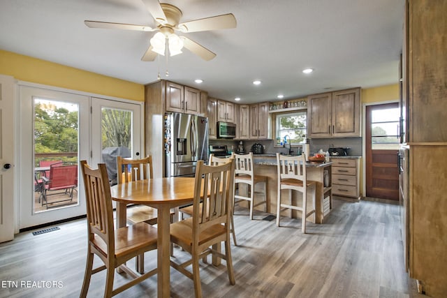 dining area with light hardwood / wood-style floors, sink, plenty of natural light, and ceiling fan