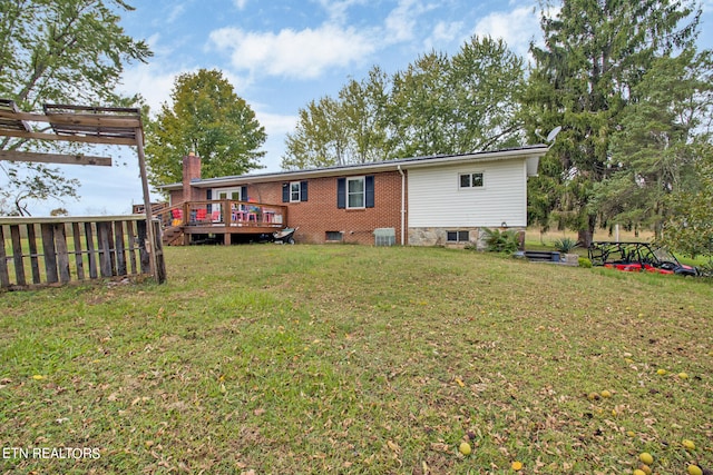 back of property with a deck and a yard