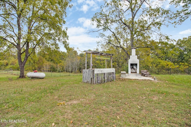 view of yard featuring an outdoor fireplace