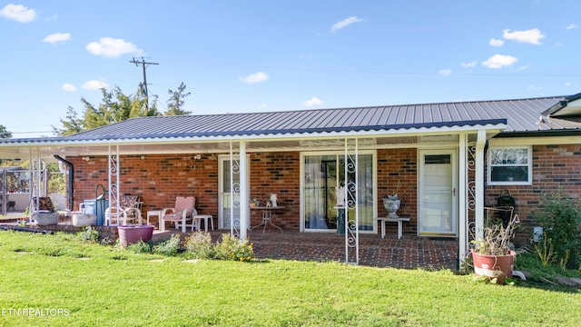 rear view of property featuring a lawn