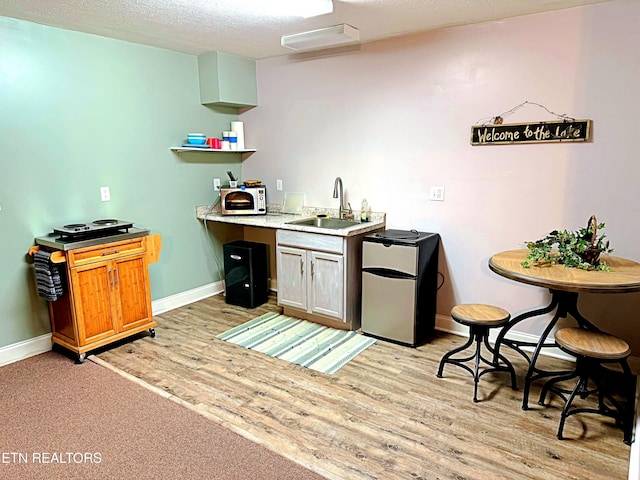 240 Mariner Point Rd, Lafollette, TN 37766 - bar featuring baseboards, a sink, light wood-style flooring, and a textured ceiling
