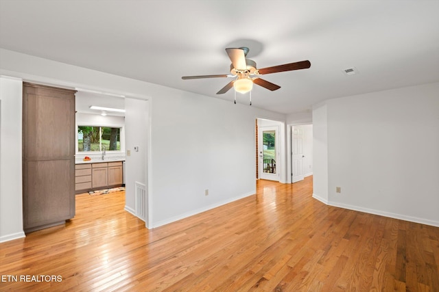 empty room with ceiling fan and light wood-type flooring