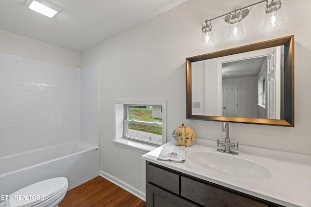 full bathroom with washtub / shower combination, wood-type flooring, vanity, and toilet