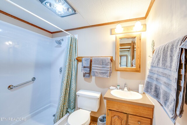 bathroom with vanity, crown molding, a shower with curtain, and toilet