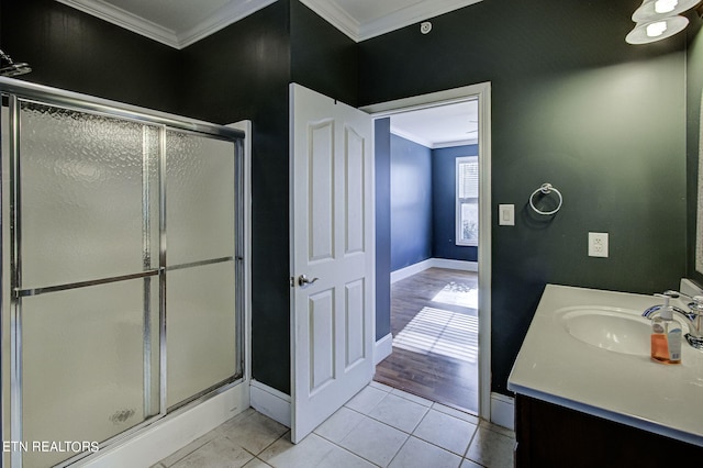 bathroom with tile patterned floors, vanity, a shower with shower door, and ornamental molding