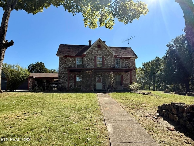 traditional-style home with stone siding and a front yard