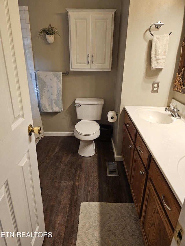 bathroom featuring vanity, toilet, and wood-type flooring