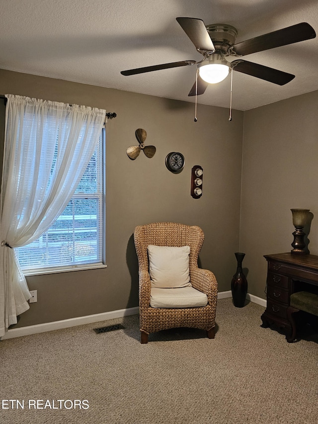 sitting room featuring ceiling fan, carpet, and a textured ceiling