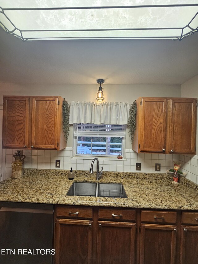 kitchen with sink, decorative backsplash, and light stone counters