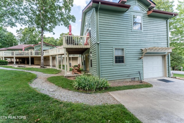 back of house with a wooden deck, a lawn, and a garage