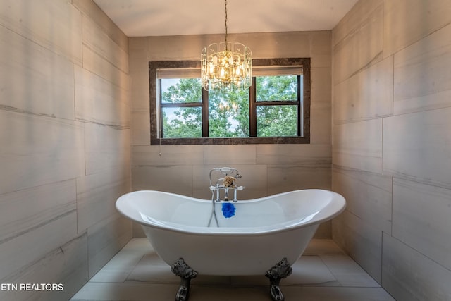 bathroom featuring tile walls, a notable chandelier, a bath, and tile patterned floors