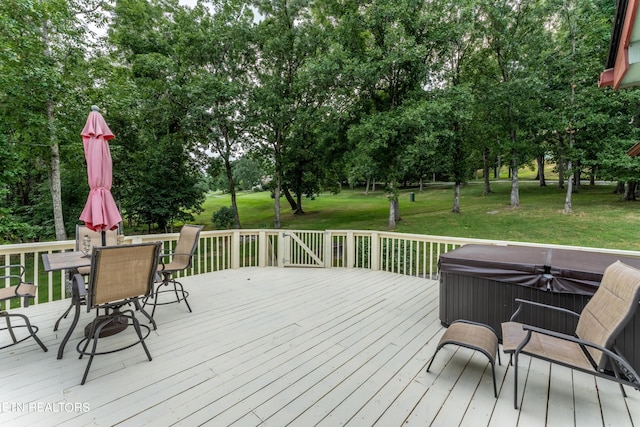 wooden deck featuring a hot tub and a yard