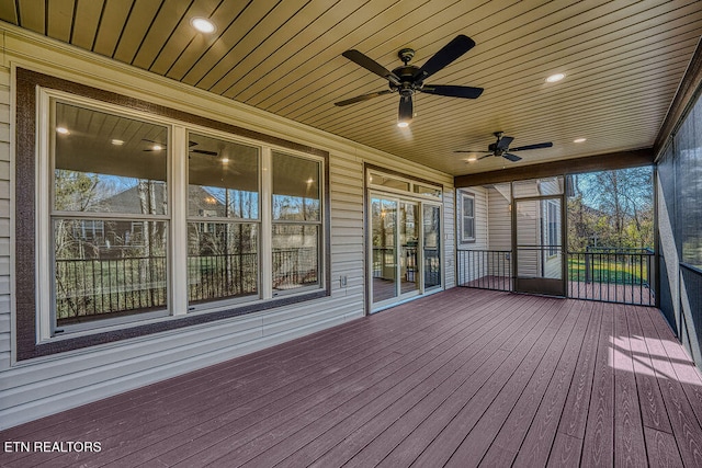 unfurnished sunroom with ceiling fan, a healthy amount of sunlight, and wood ceiling