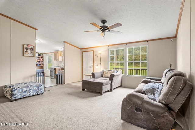 living room with light carpet, a textured ceiling, ornamental molding, and ceiling fan