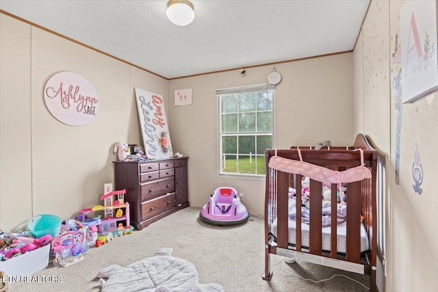 carpeted bedroom with crown molding, a crib, and a textured ceiling