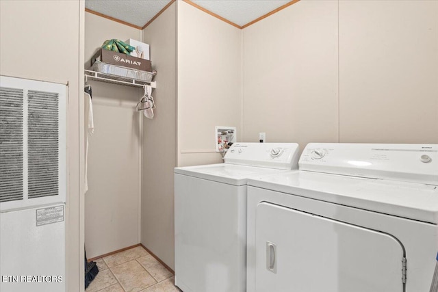 washroom with washing machine and clothes dryer, crown molding, light tile patterned floors, and a textured ceiling