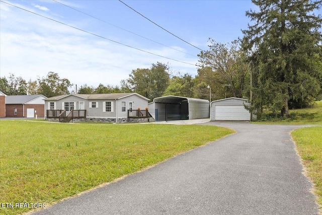 view of front of property with an outbuilding, a carport, a front yard, and a garage