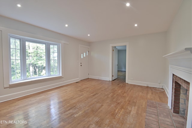 unfurnished living room with light hardwood / wood-style flooring and a fireplace