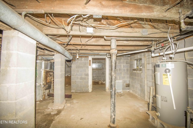 unfinished basement featuring water heater and radiator heating unit
