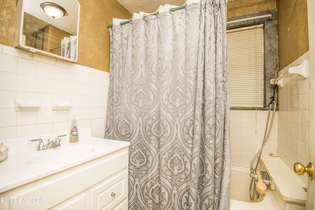 full bath featuring tile walls, a wainscoted wall, vanity, and shower / bath combination with curtain