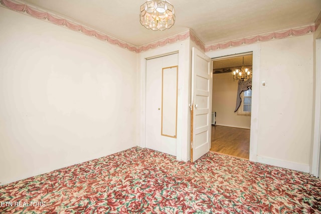 spare room with an inviting chandelier and carpet floors